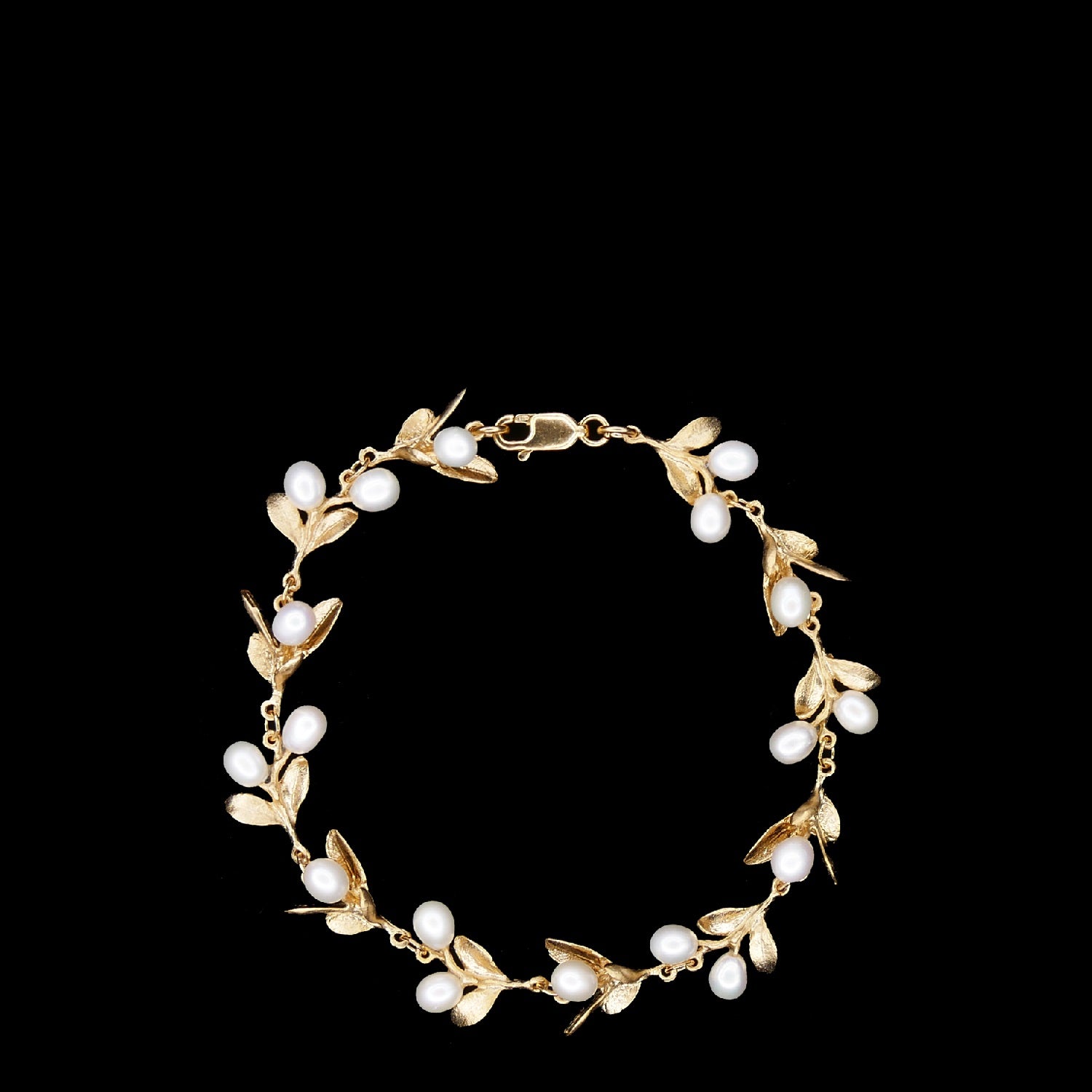 Gold bracelet with leaf-shaped charms and white pearl-like beads arranged in a circular pattern on a black background.