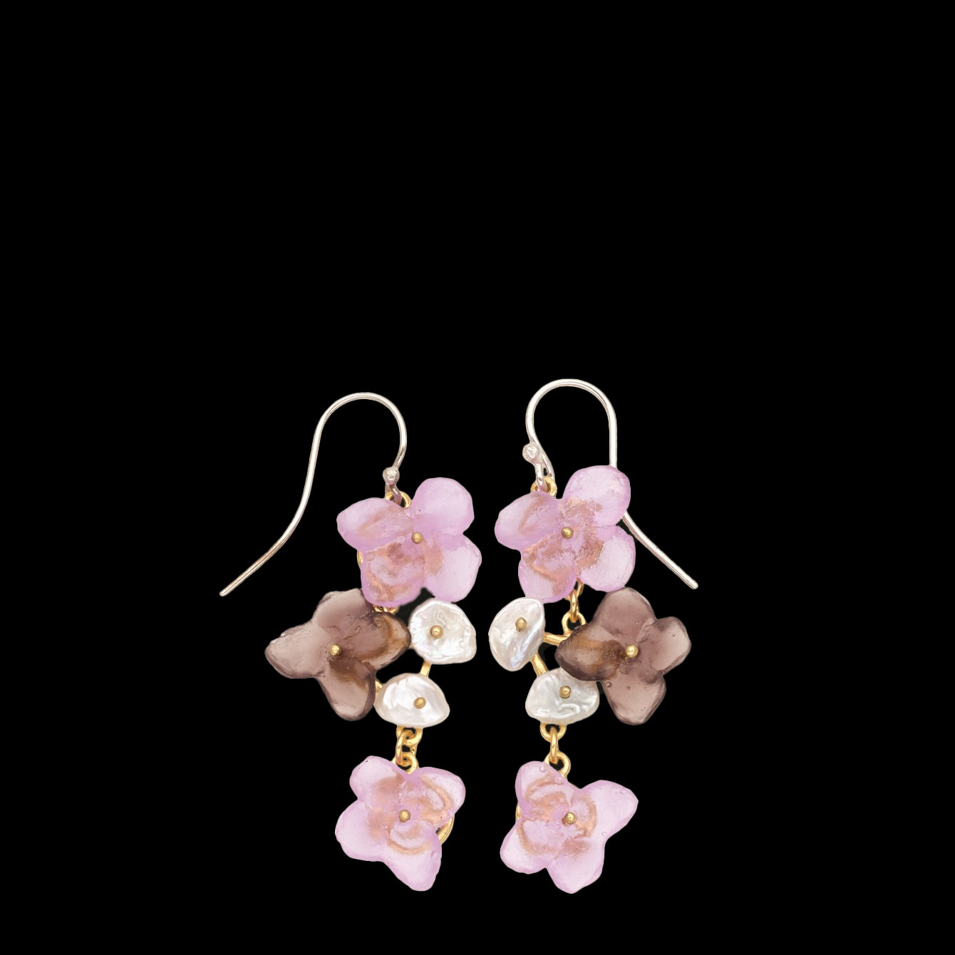 A pair of dangle earrings featuring pink and brown flower-shaped elements with small white beads, set against a black background.