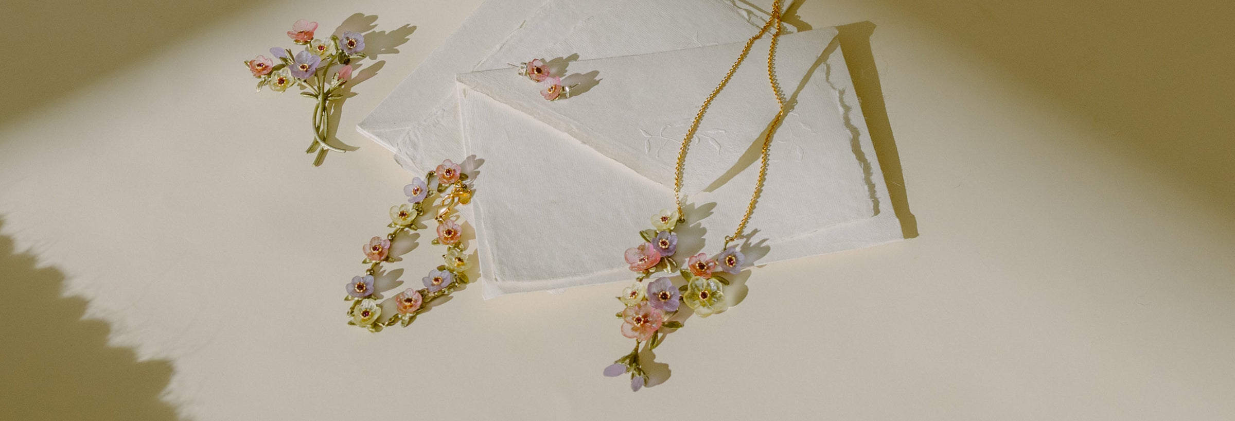 A woman in a white dress lies on a textured surface, holding her hair and looking up, with a bouquet of pink flowers beside her.