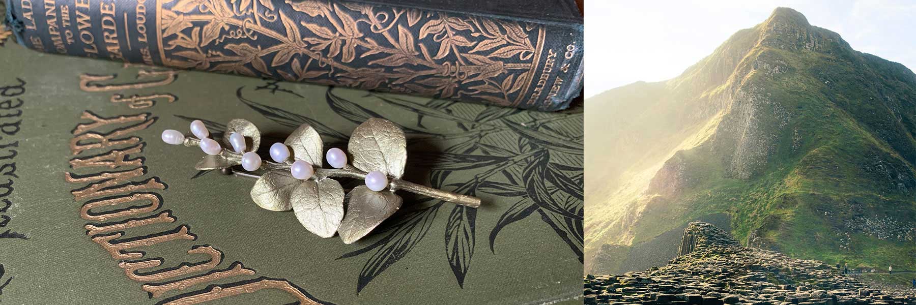 A brooch with pearl-like beads rests on vintage books with ornate covers; beside it, a sunlit mountain rises above a mossy stone structure.
