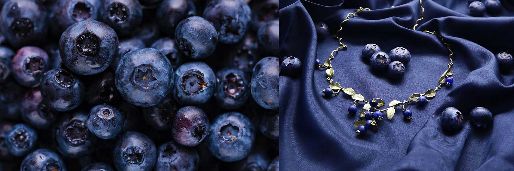 Close-up of fresh blueberries on the left; on the right, a gold necklace with blue charms is displayed on dark fabric alongside a few blueberries.