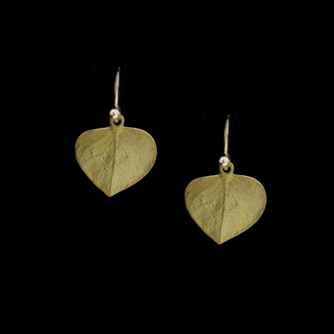 The Eucalyptus Earrings - Leaf Wire Drop feature green-toned, heart-shaped leaf bronze with a textured surface and hand patina finish, shown against a black background.