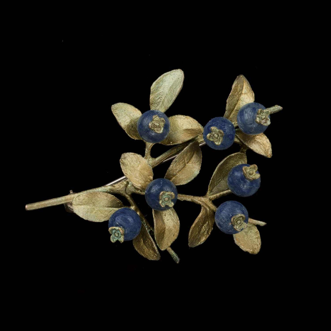 Image of the Michael Michaud Blueberry Brooch on a black background