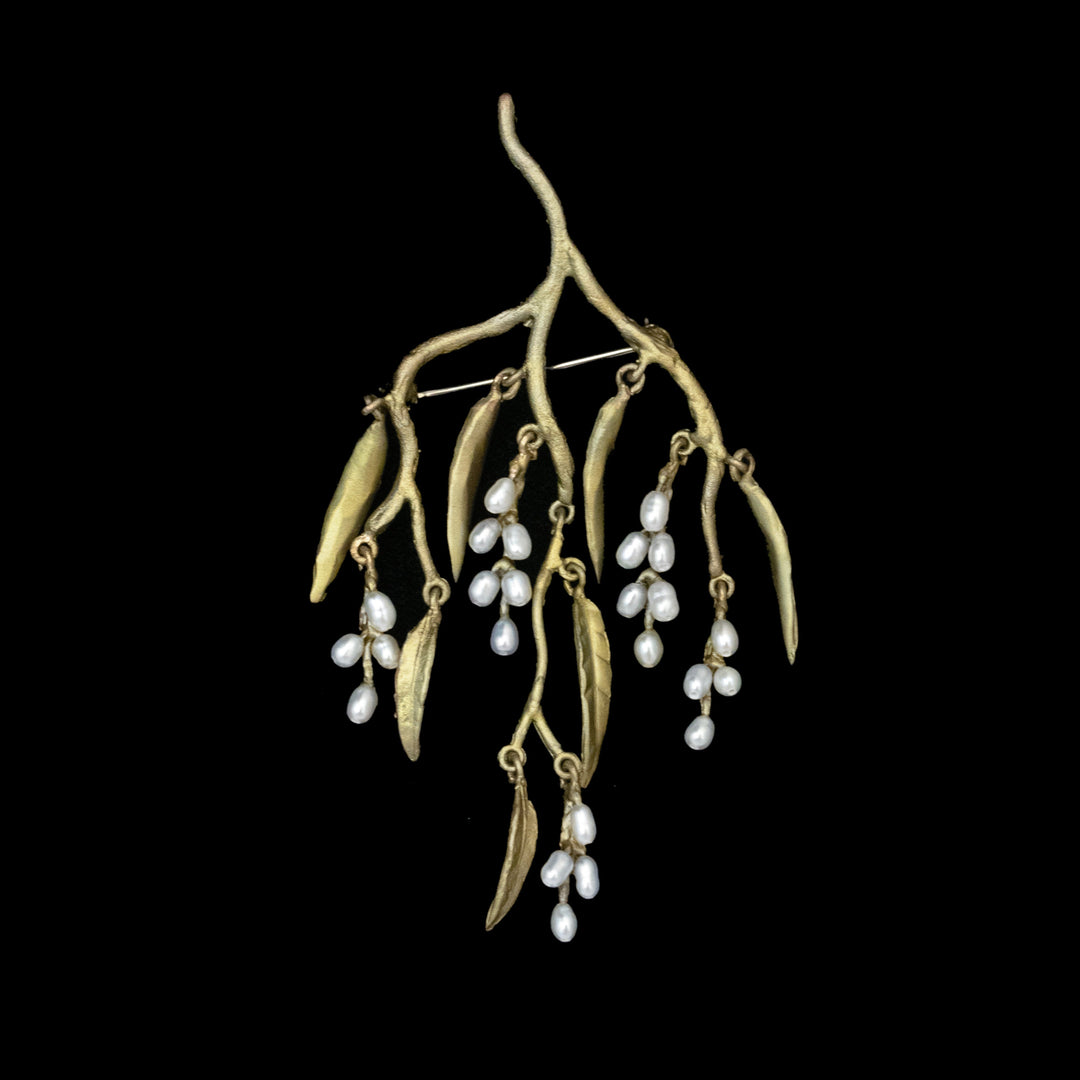 The Weeping Willow Brooch features green branches with elongated leaves and clusters of freshwater seed pearls, beautifully displayed against a black background.