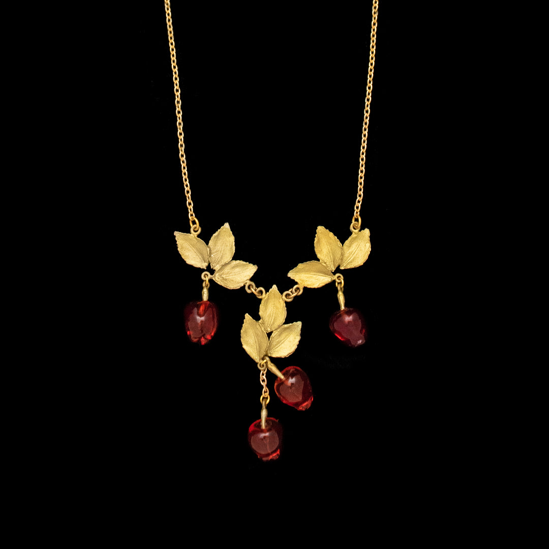 Image of the Michael Michaud Delicious Apple Necklace on a black background