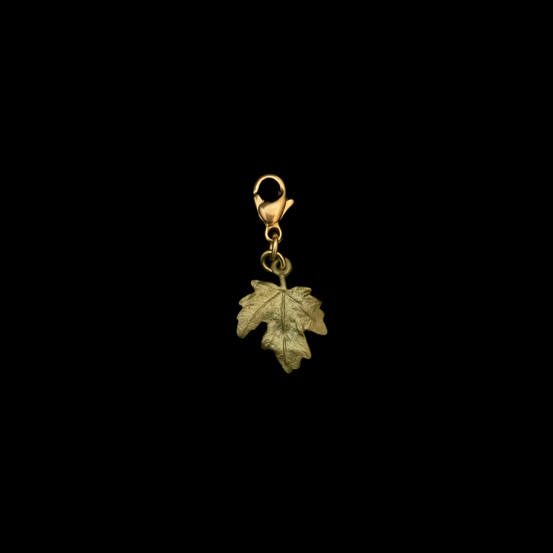 Image of the Michael Michaud Petite Leaf Charm on a black background