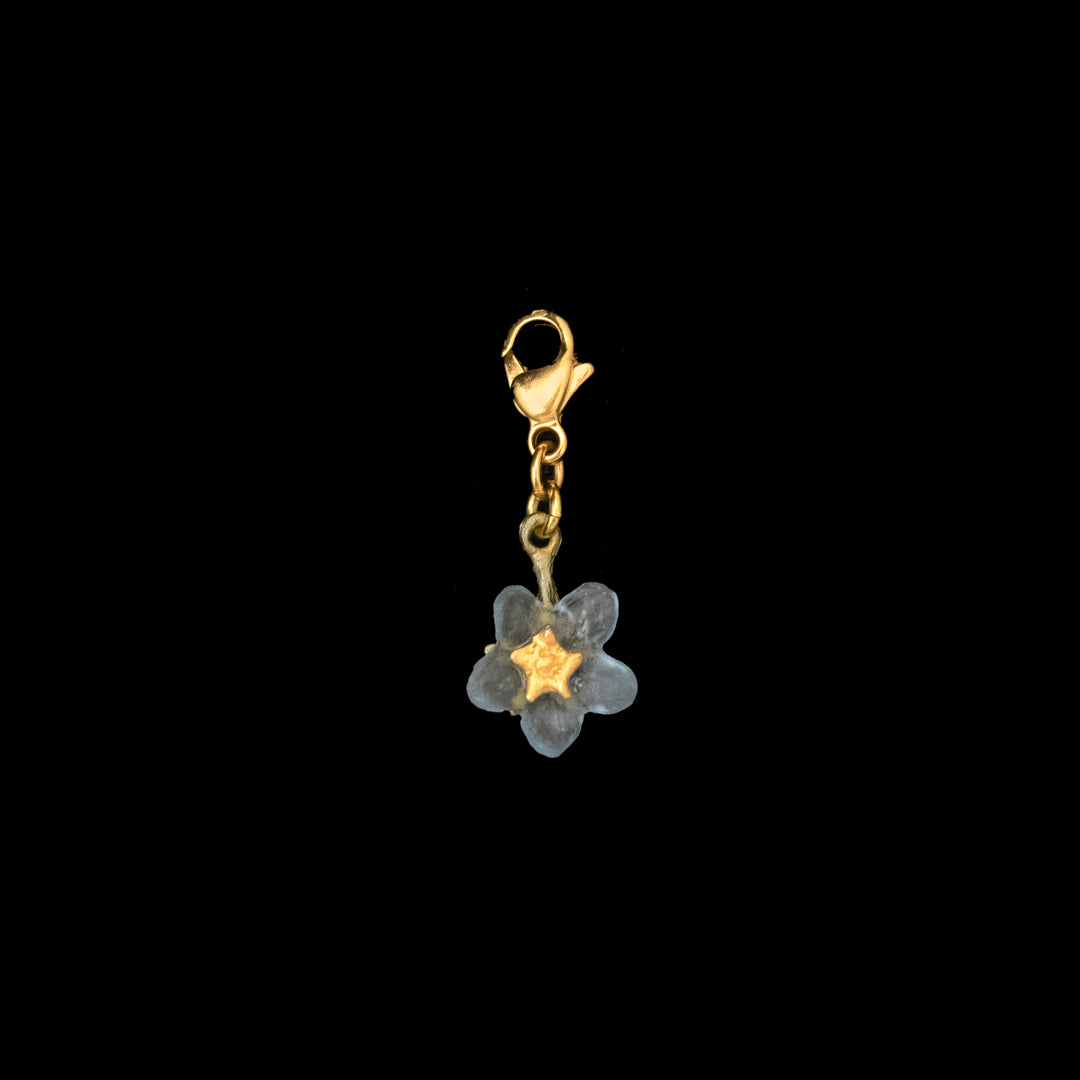 Image of the Michael Michaud Forget Me Not Charm on a black background