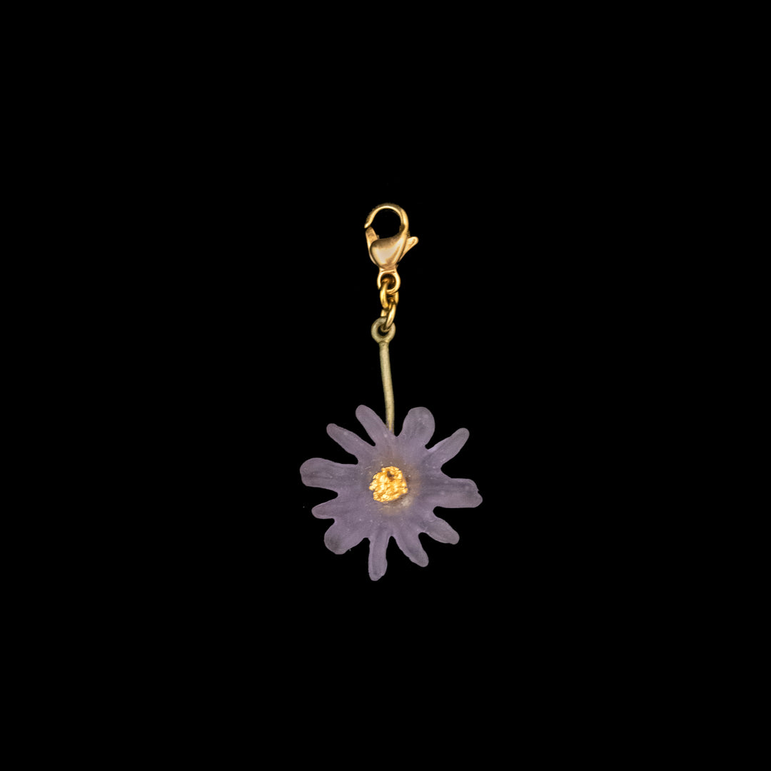 A handcrafted bronze Aster Charm featuring a purple, daisy-shaped flower with a yellow center, inspired by Victorian flower jewelry, isolated on a black background.