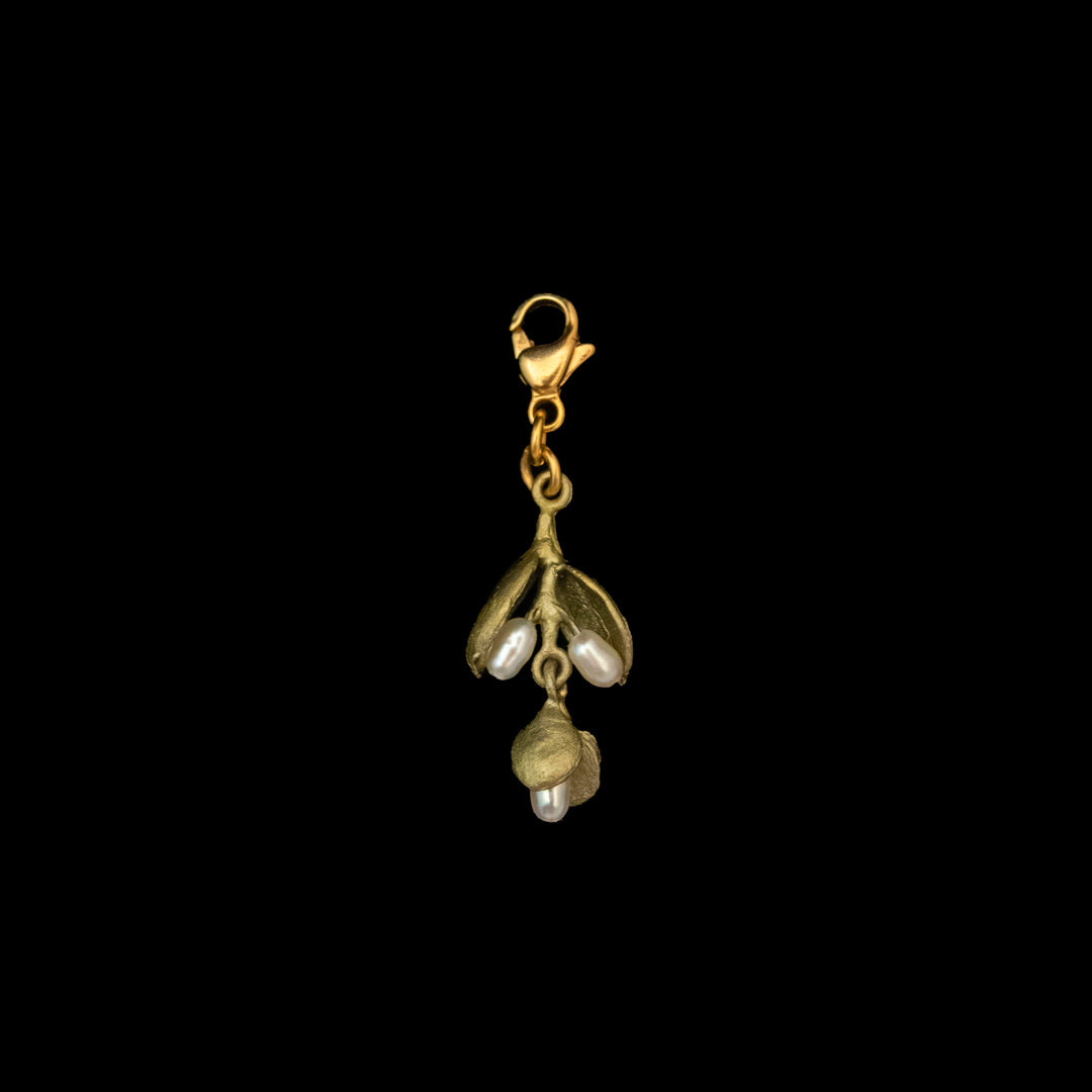 A small green charm featuring a cluster of three freshwater pearls, attached to a lobster clasp for easy wear, evokes protection and healing, elegantly displayed on a black background.