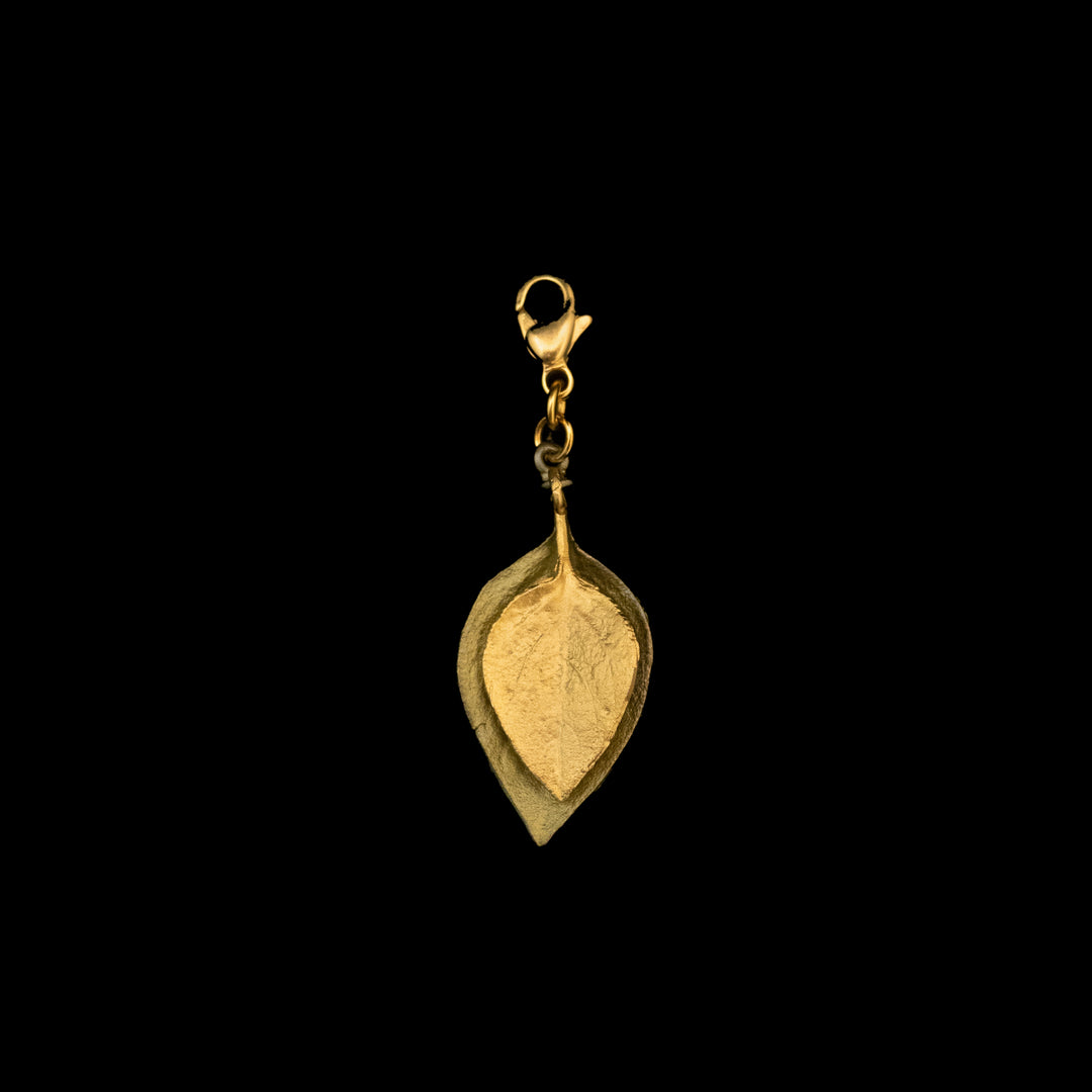 A two leaf design, the larger one in green, the smaller one in front in gold plate with a lobster clasp, photographed against a black background.