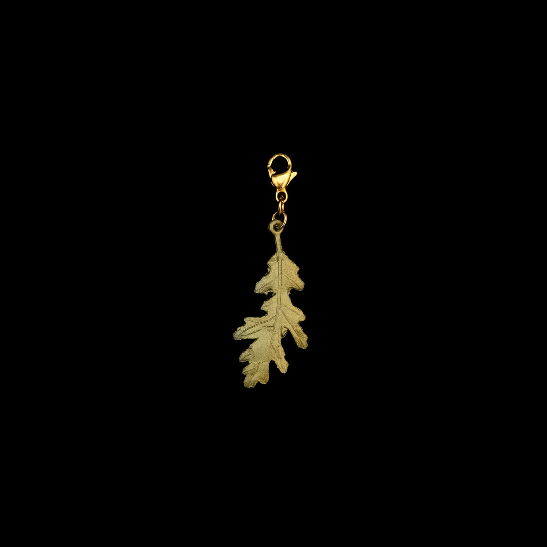 A bronze oak leaf charm with a green patina and a clasp for attaching it to a bracelet or necklace.
