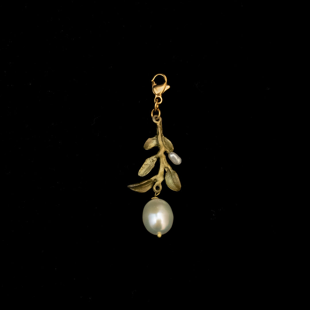 Green pendant with a Victorian vine charm, featuring leaf and branch design, a clasp at the top, and two pearls—one large baroque freshwater pearl and one small—set against a black background.