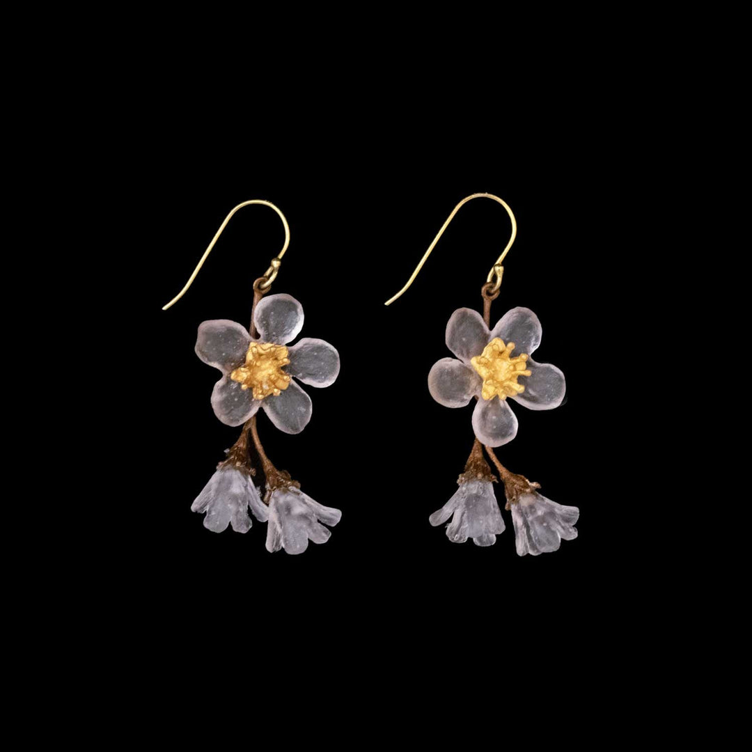 A pair of golden hook earrings featuring translucent handcrafted glass flower designs with yellow centers and small hanging bell-shaped blooms, set against a black background—perfect for lovers of floral-inspired jewelry.