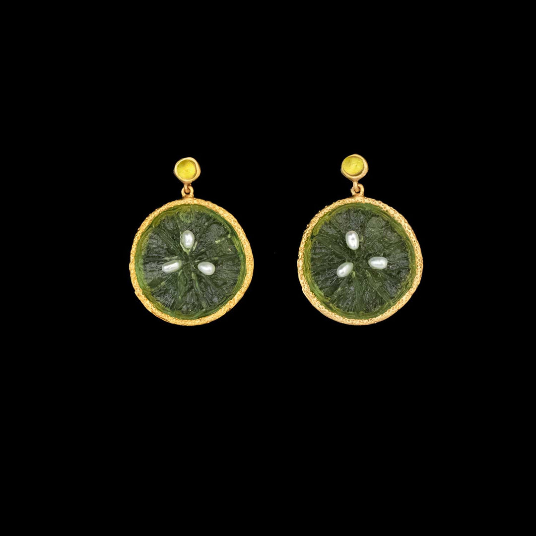 Pair of earrings with green circular designs and gold accents on a black background