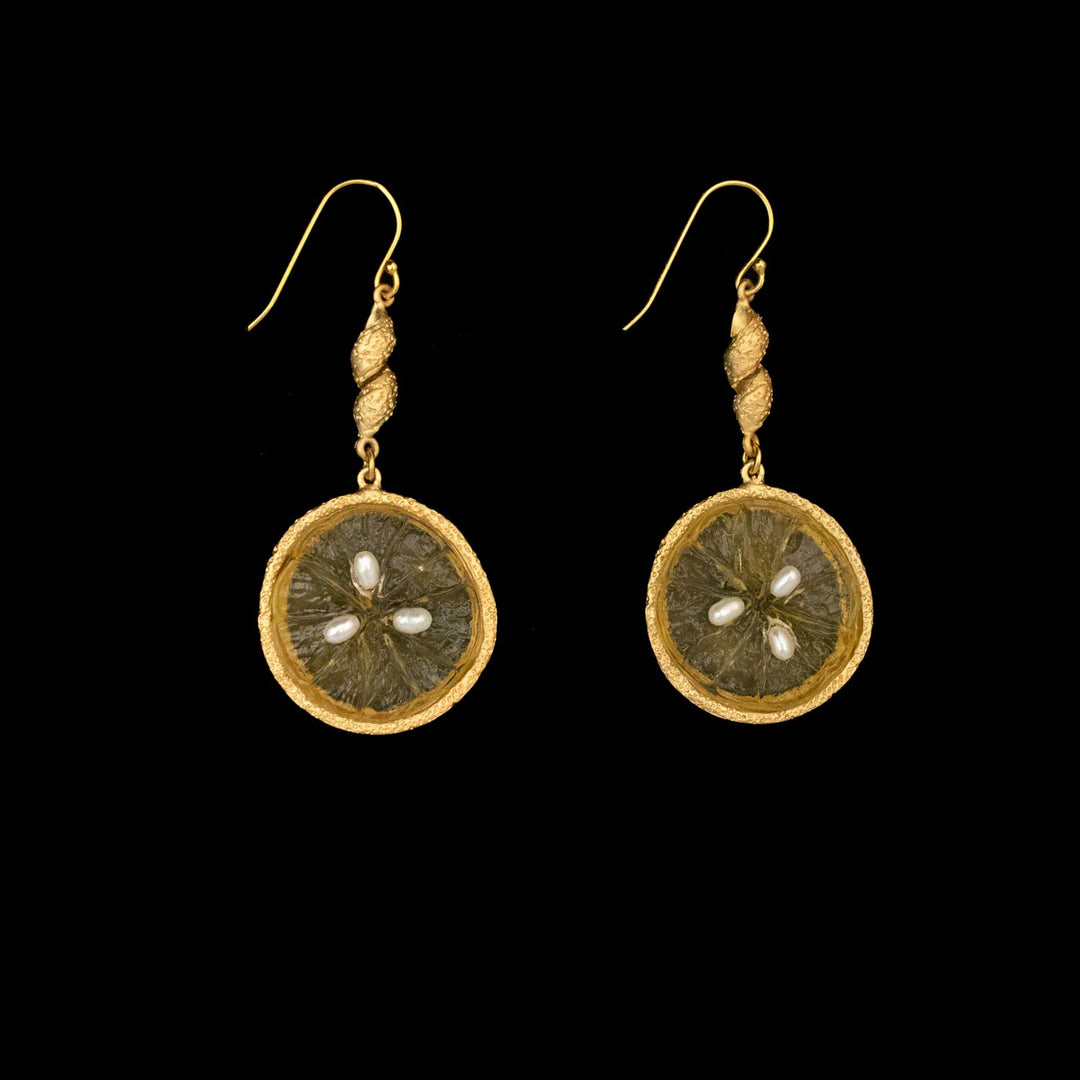 A pair of 24kt gold plated dangle earrings with round, textured glass pendants with pearl accents, displayed on a black background—a stunning piece of handmade botanical jewelry.