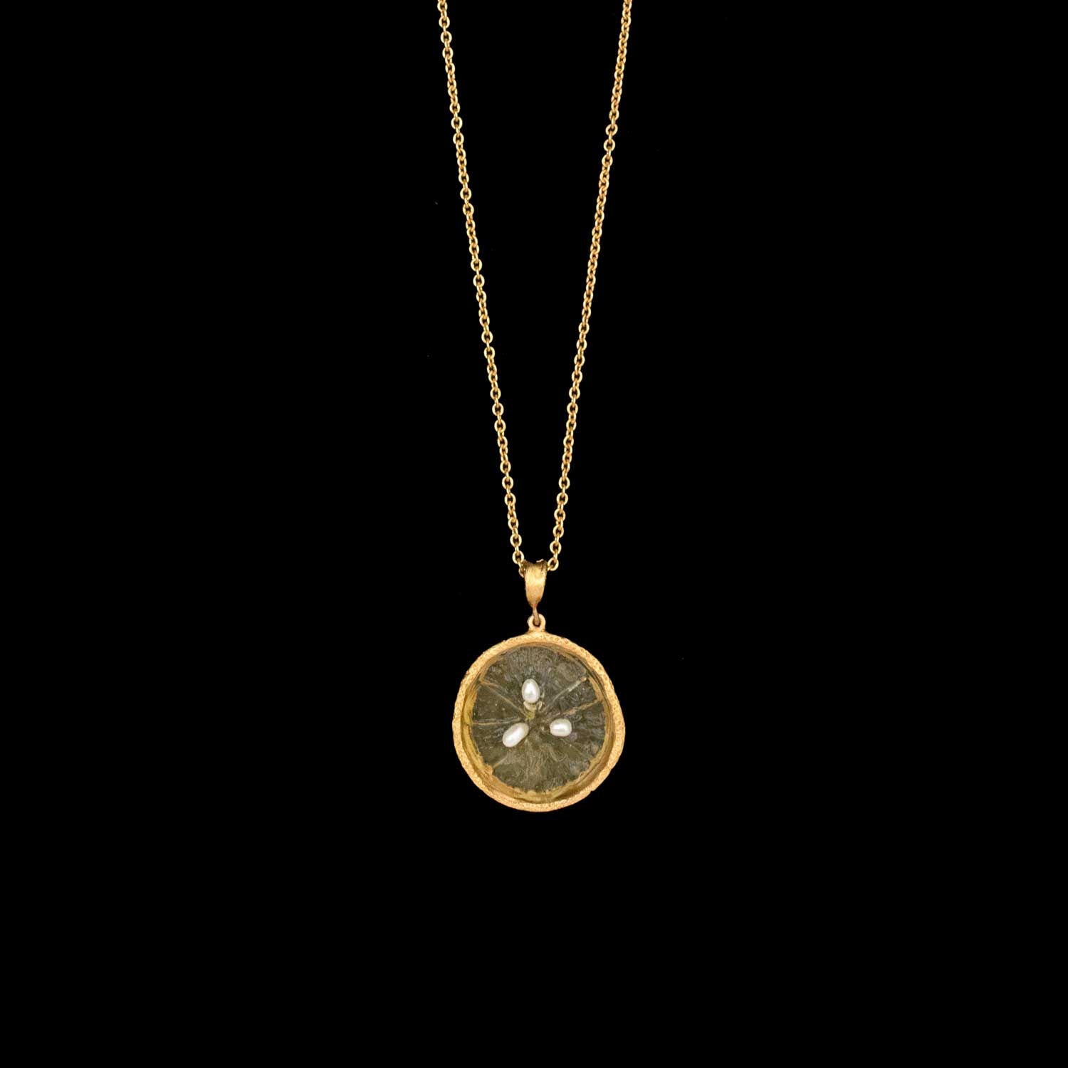 The Citrus Pendant - Lemon features a gold chain with a circular lemon slice pendant, bordered in 24kt gold plated bronze and accented with three small white stones—a signature design by Michael Michaud Jewelry.