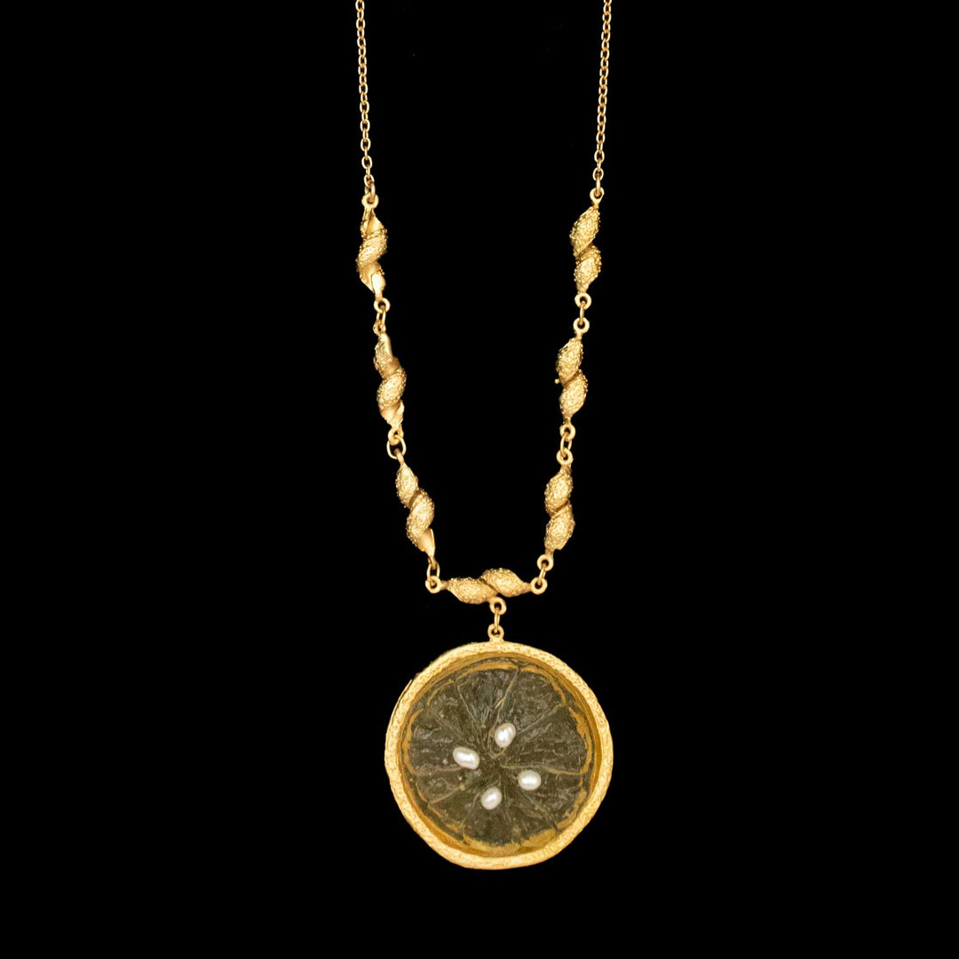 The Citrus Pendant - Large Lemon by Michael Michaud Jewelry features a 24kt gold plated, textured chain with a round-shaped lemon pendant resembling a dried citrus slice set in gold, shown on a black background.