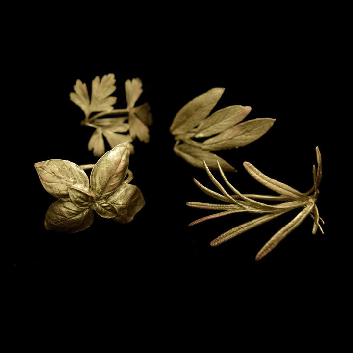 Image of the Michael Michaud Italian Herbs Bronze Assortment for Four Napkin Rings on a black background