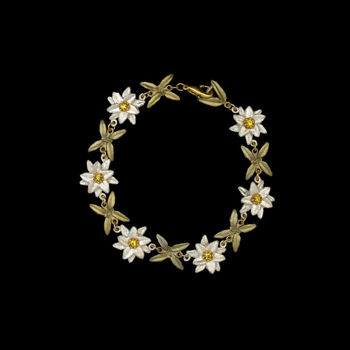 A gold Edelweiss bracelet featuring alternating white and yellow flower-shaped links, connected by small gold rings and inspired by The Sound of Music jewelry, displayed on a black background.