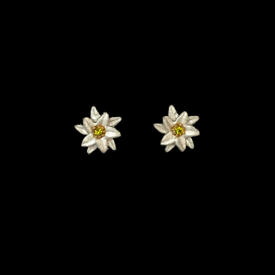 A pair of silver Edelweiss earrings with yellow crystal centers, inspired by The Sound of Music jewelry, displayed on a black background.