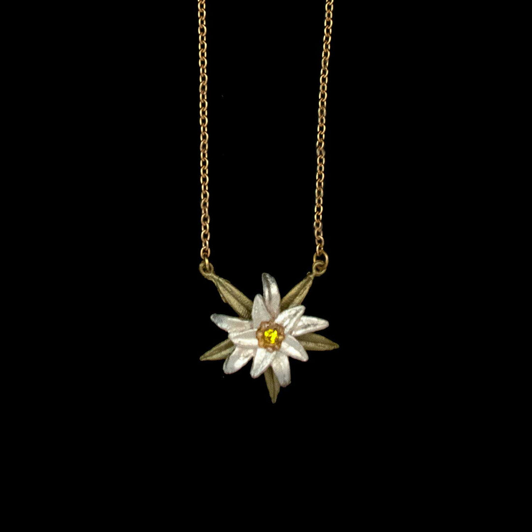 Golden chain necklace featuring an Edelweiss pendant shaped like a white and yellow flower, inspired by Sound of Music jewelry, displayed against a black background.