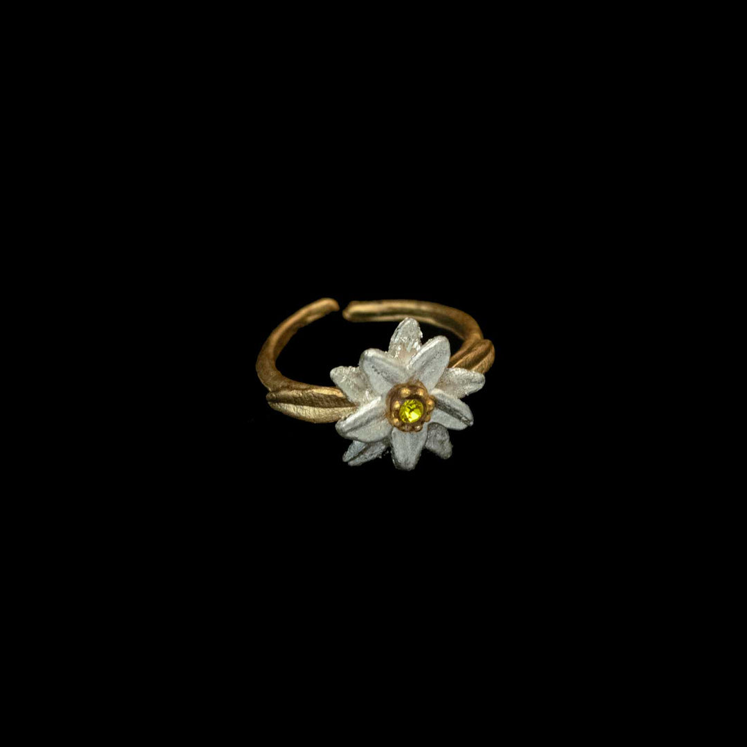 A golden Edelweiss ring featuring a white flower with a yellow crystal center, inspired by The Sound of Music jewelry, set against a black background.