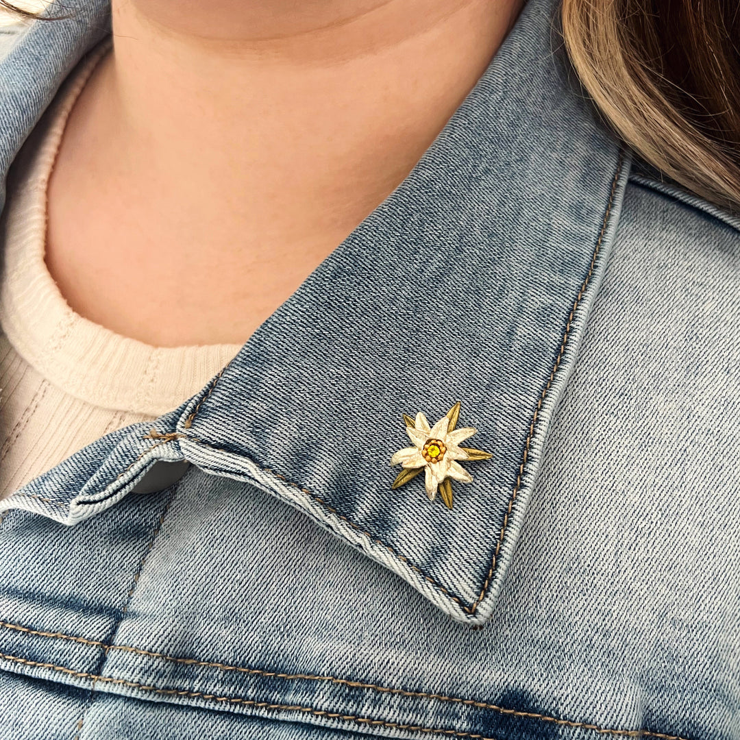 Close-up of a denim jacket with a floral brooch