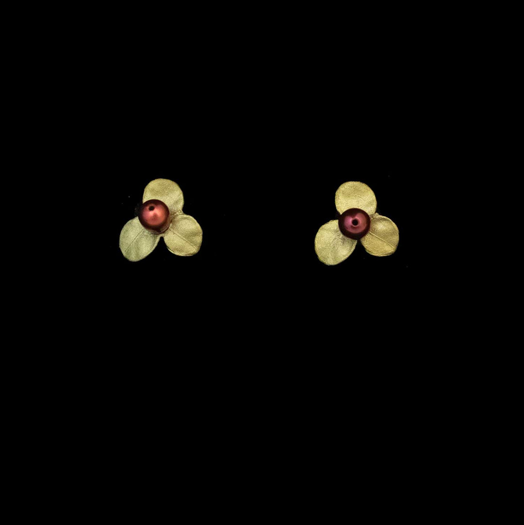 Firethorn earrings crafted from hand-patinated bronze feature small petals with vibrant red freshwater pearl centers, elegantly displayed on a black background.