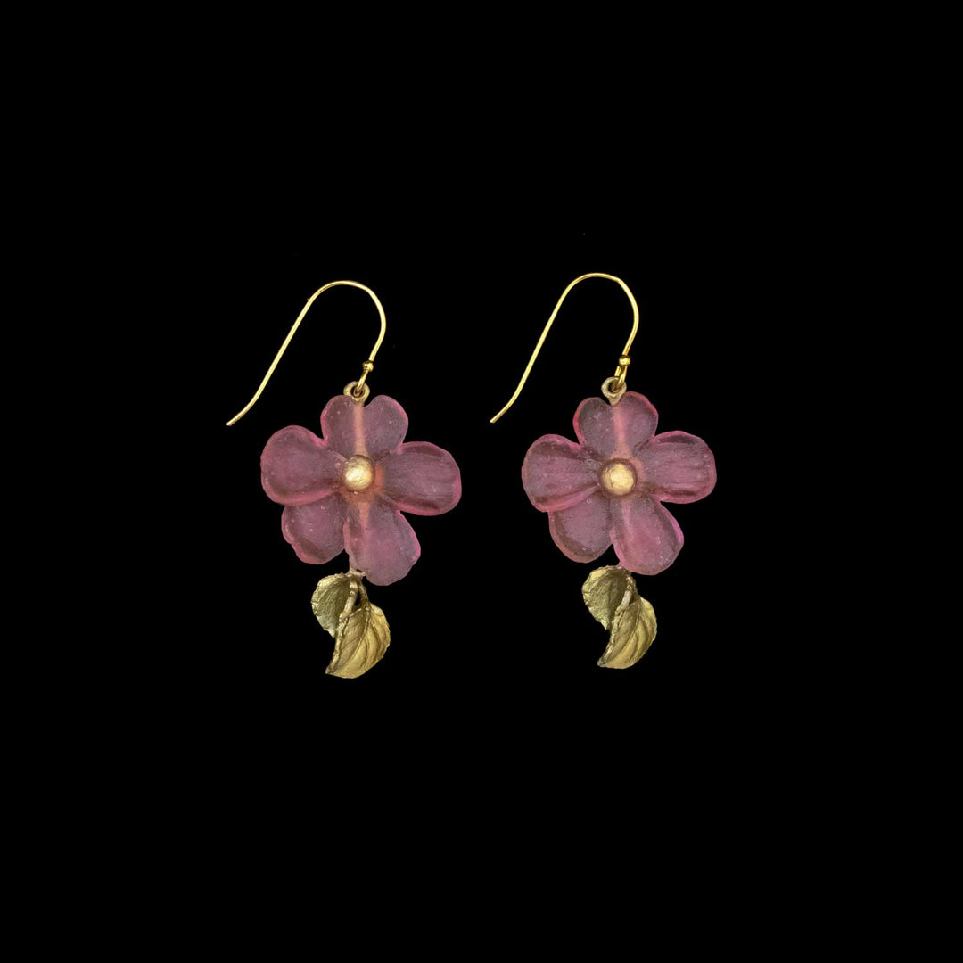 A pair of hook earrings with pink flower-shaped pendants and small green leaves hanging below each flower, these handcrafted flower earrings make stunning nature-inspired accessories against a black background.