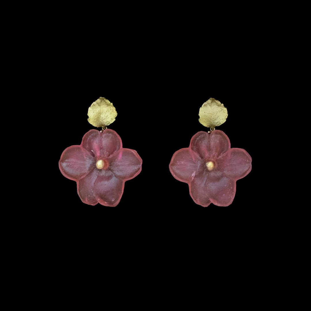 A pair of handcrafted flower earrings with green circular studs and large, deep pink, Impatiens-inspired pendants, set against a black background.
