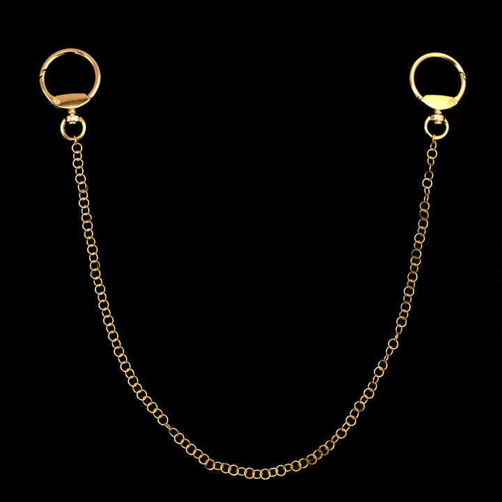 A gold chain with a circular clasp at each end, displayed against a black background.