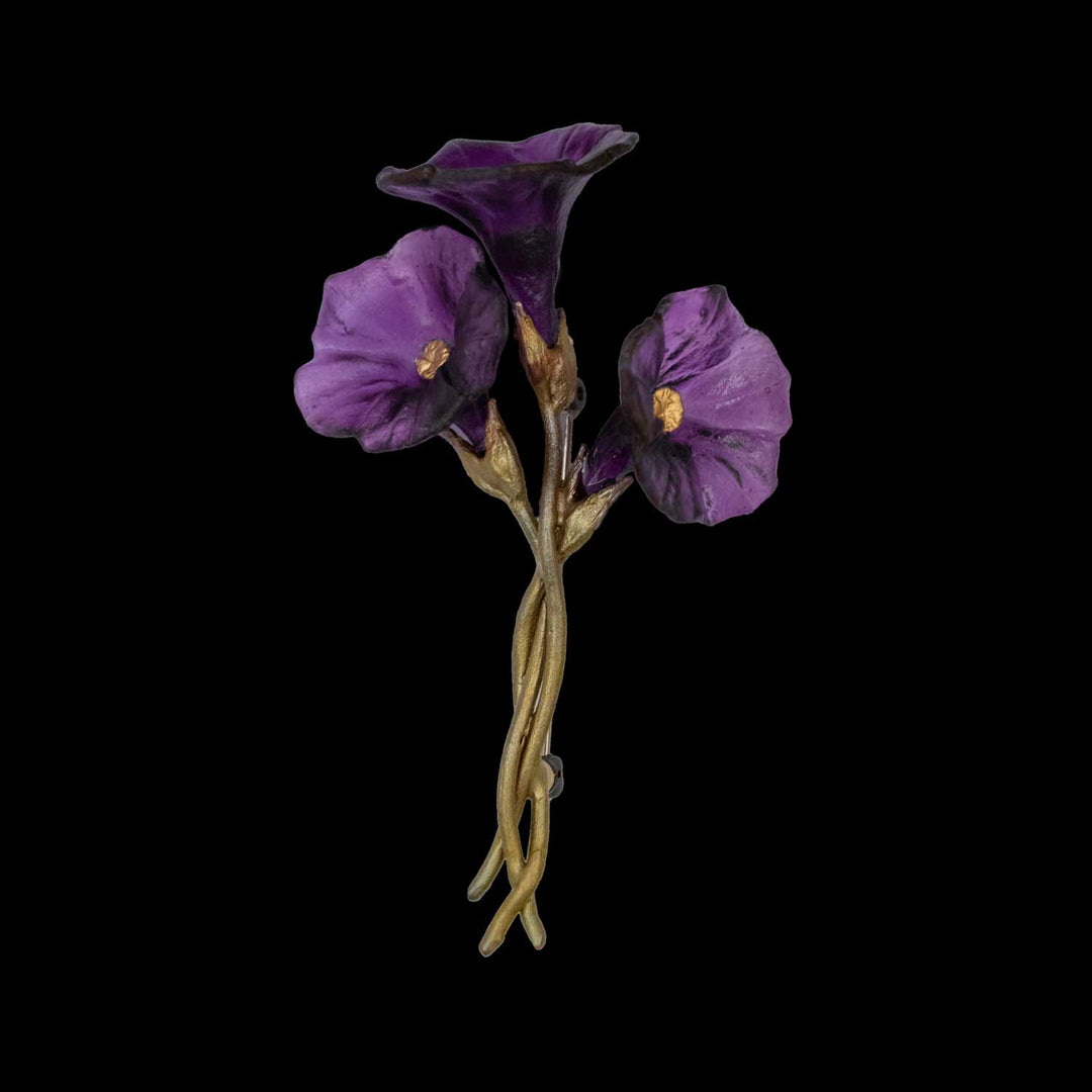 A handcrafted bronze Petunia brooch featuring three purple flower blossoms and gold stems on a black background, bringing nature-inspired elegance to any look.