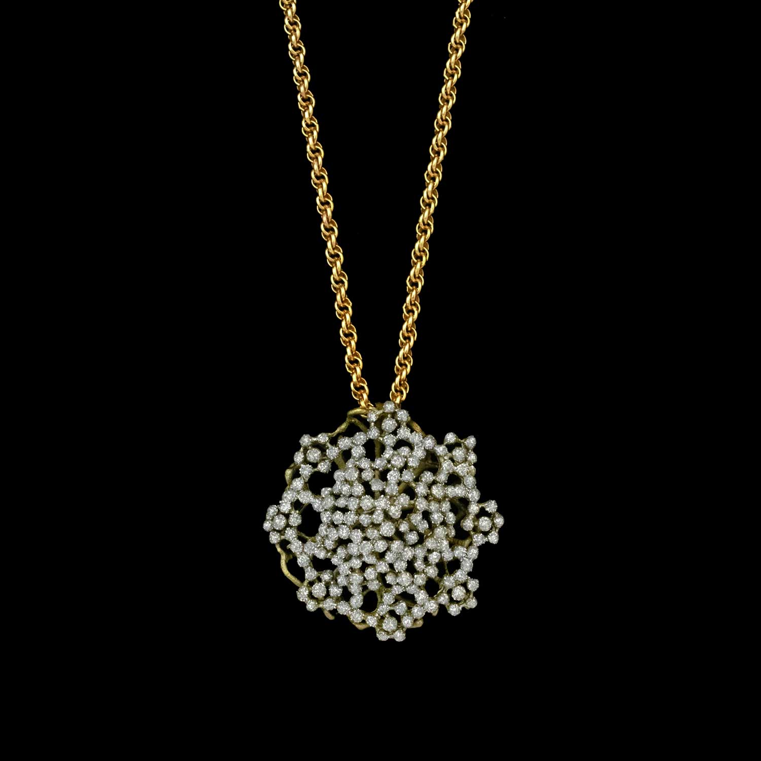 Gold necklace with a intricate pendant on a black background