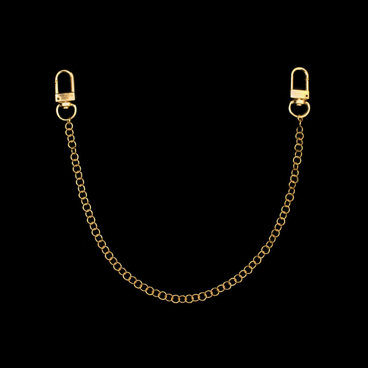 A gold chain with clasps at both ends is displayed against a black background.