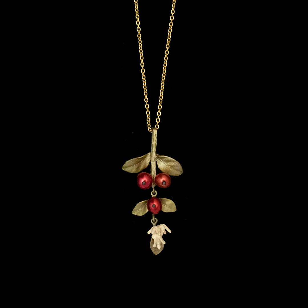 The Unroasted Coffee Bean Pendant - Large is a botanical jewelry necklace featuring a pendant shaped like a branch with three red berries, green leaves, and a small white flower, beautifully displayed against a black background.