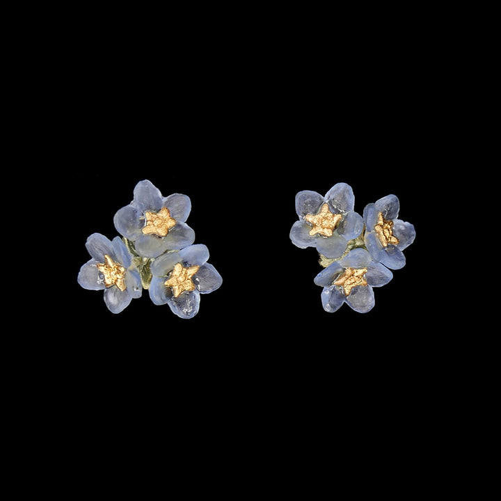 A pair of bronze earrings featuring pale blue glass flowers with 24kt gold plated pollen stems on silver posts.