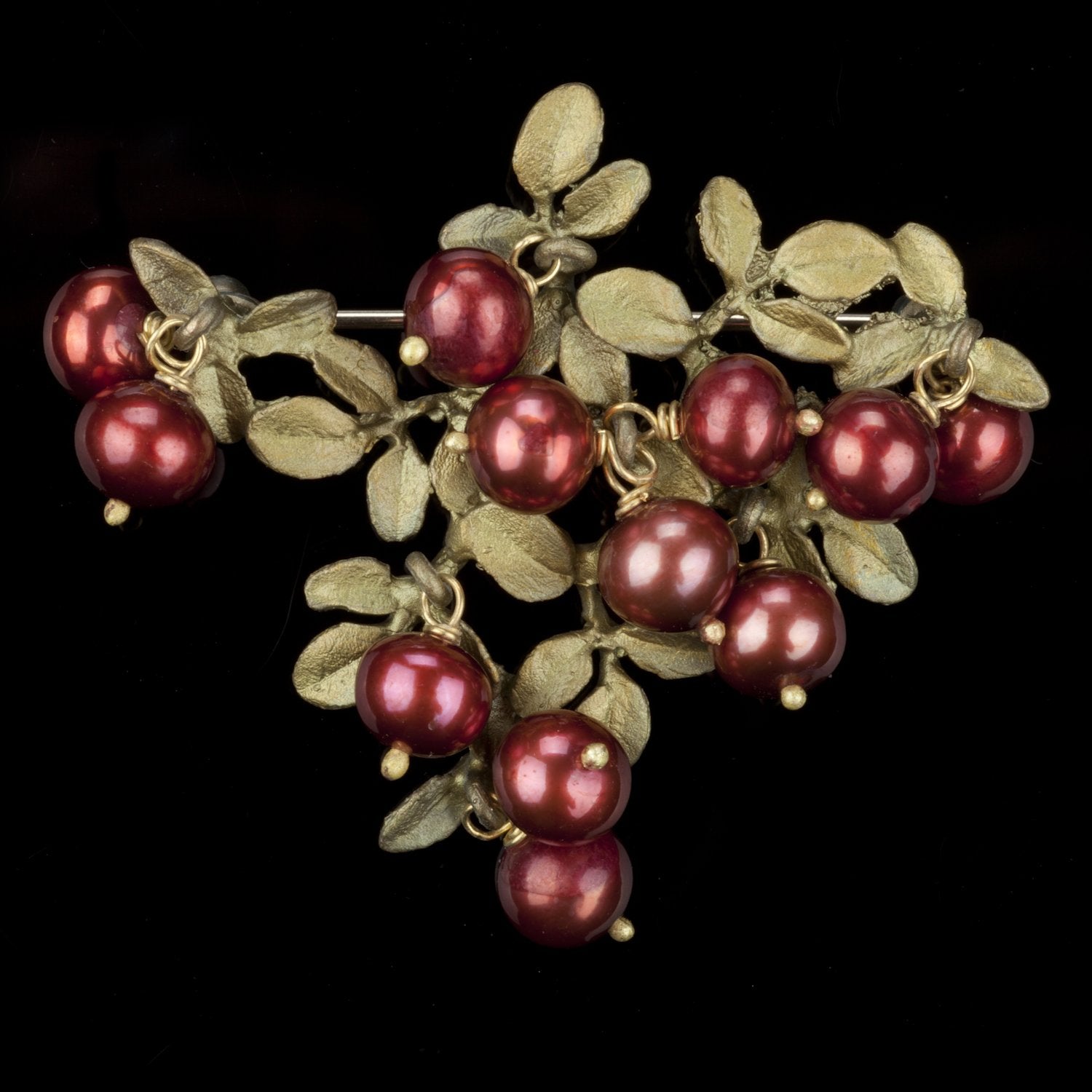 Image of the Michael Michaud Cranberry Brooch on a black background