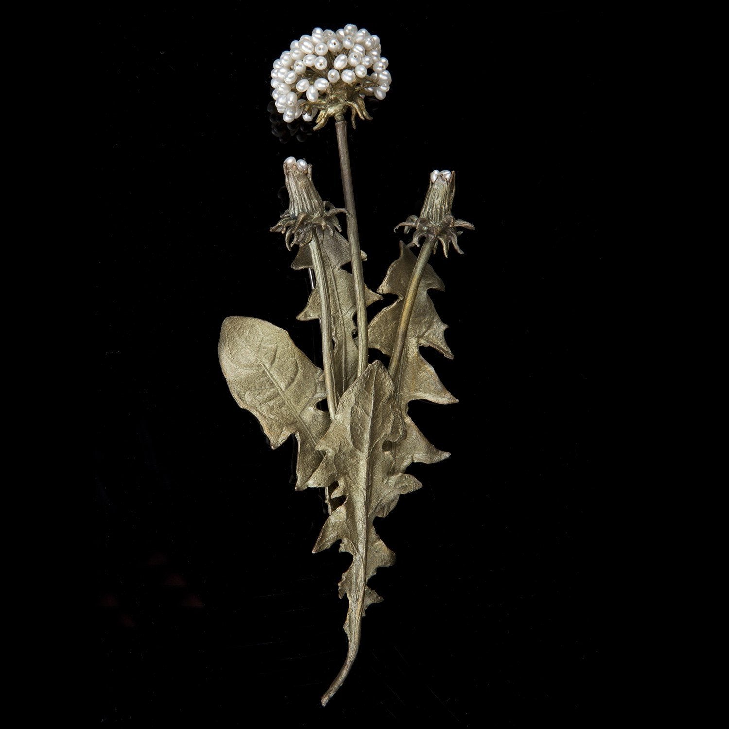 Image of the Michael Michaud Dandelion Brooch on a black background