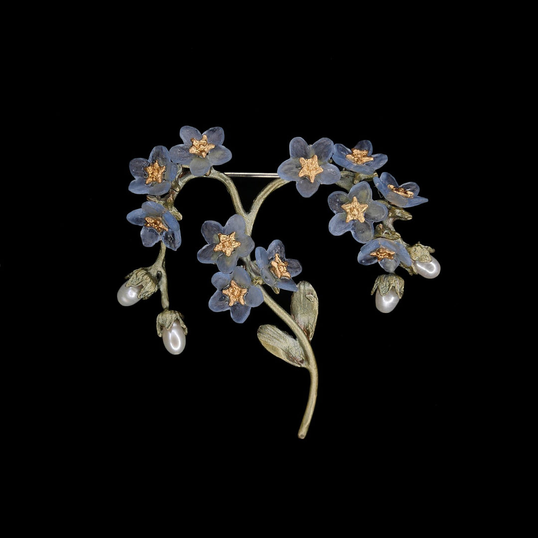 Image of the Michael Michaud Forget Me Not Brooch on a black background