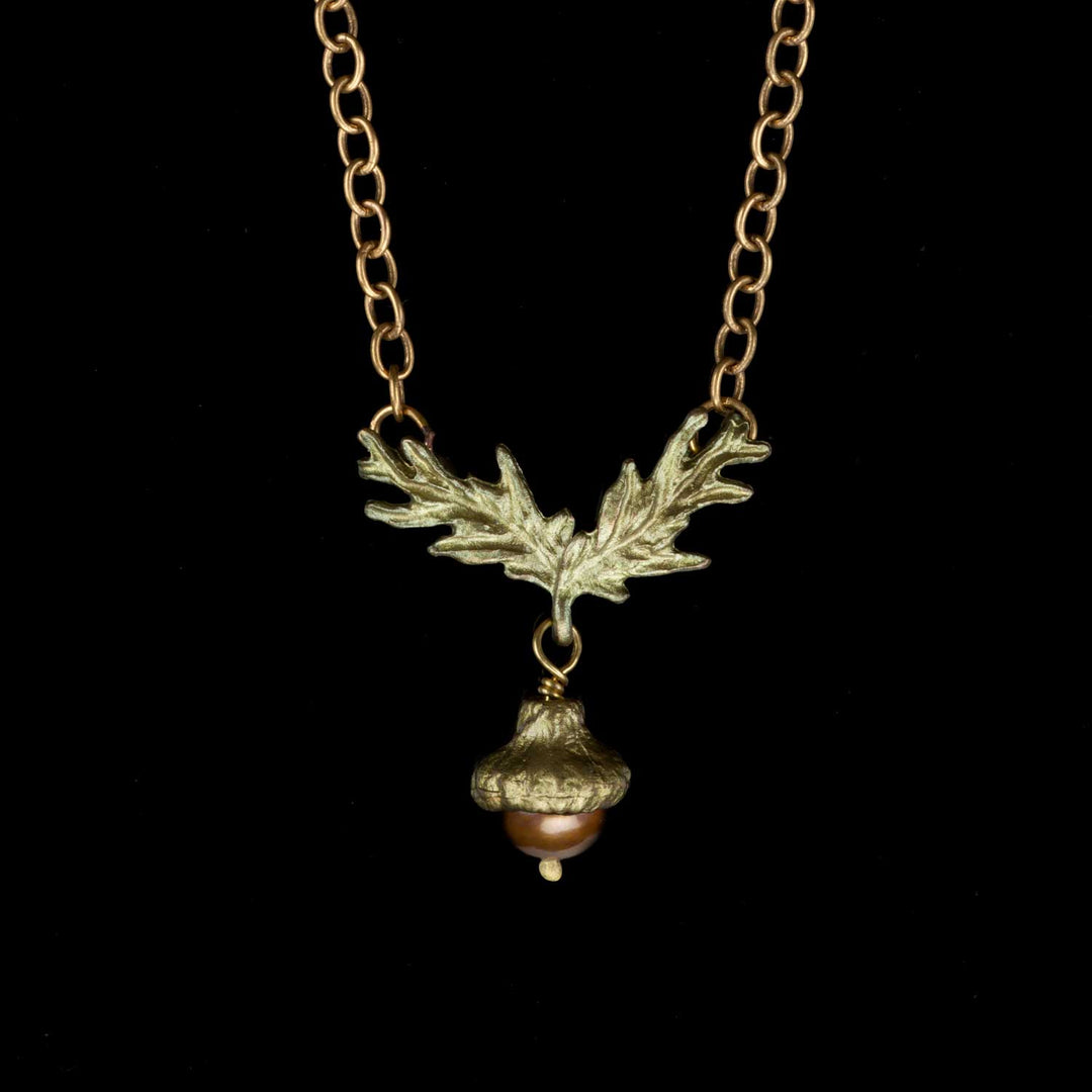 A bronze acorn pendant necklace with a chocolate freshwater pearl acorn dangle, displayed against a black background.