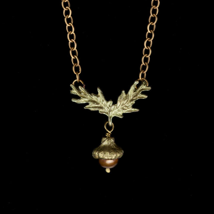 A bronze acorn pendant necklace with a chocolate freshwater pearl acorn dangle, displayed against a black background.