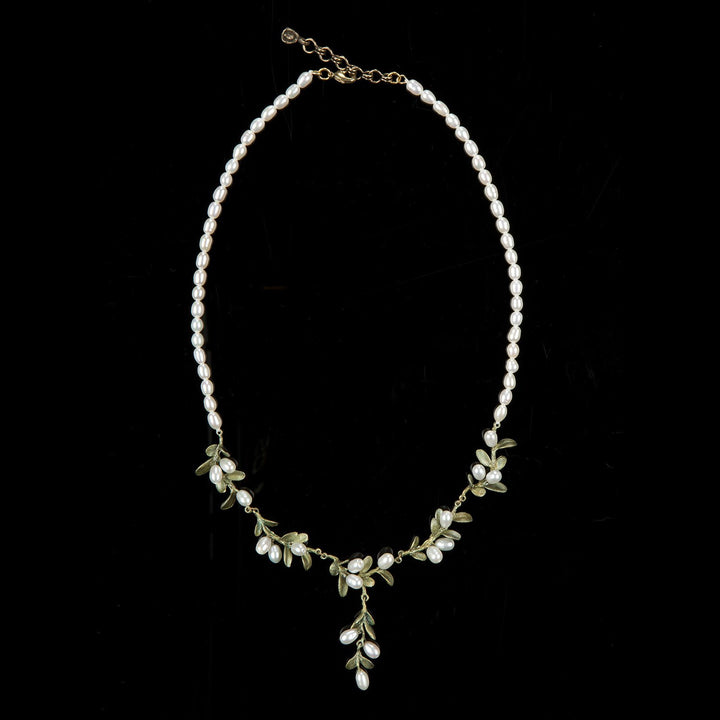Delicate pearl necklace with gold chain and small green boxwood leaf accents.