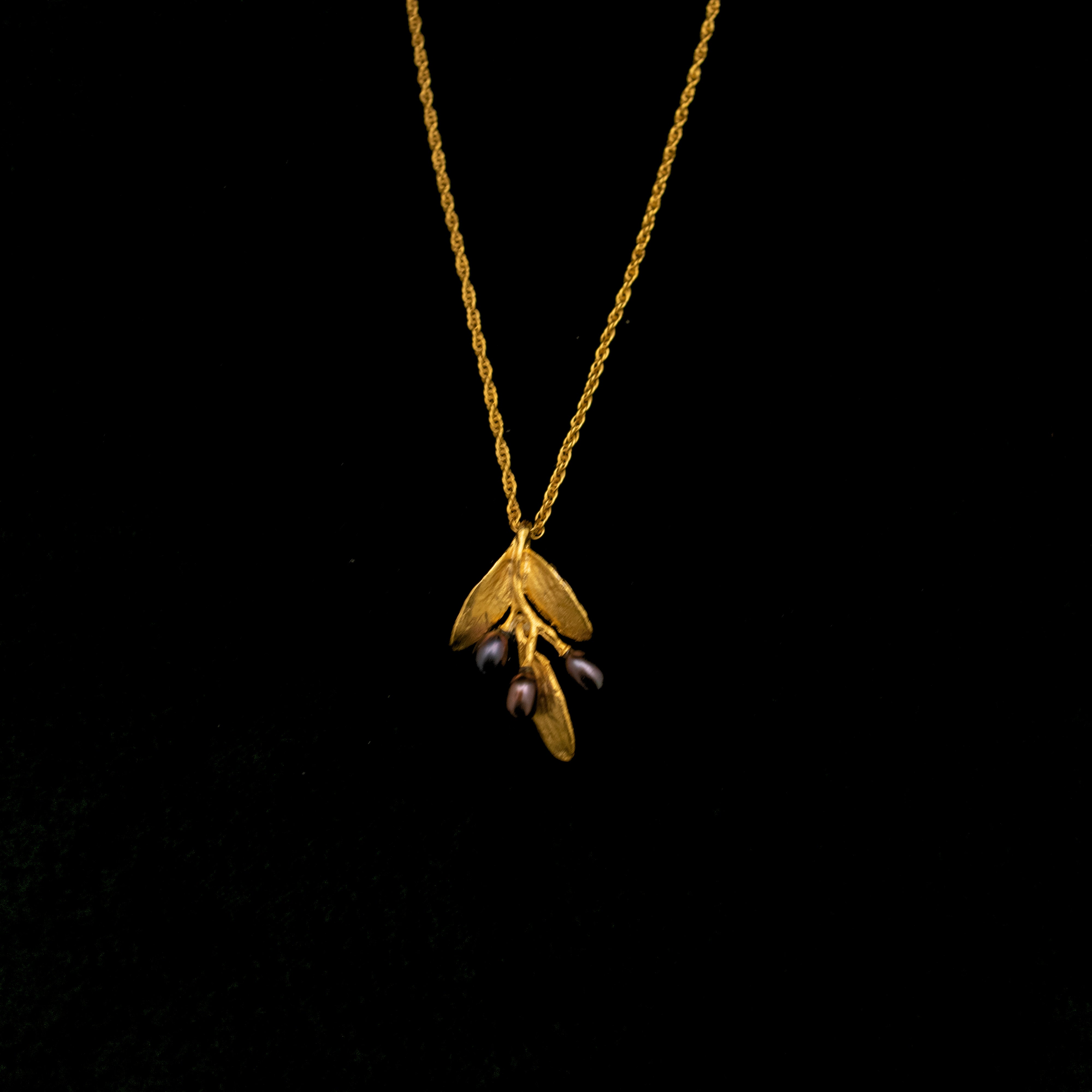 Image of the Michael Michaud Fine Olive Gold Pendant on a black background