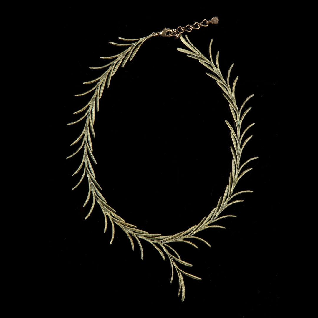 A bronze necklace designed as a series of interlinked rosemary leaf sprigs with a green tint, displayed against a black background.