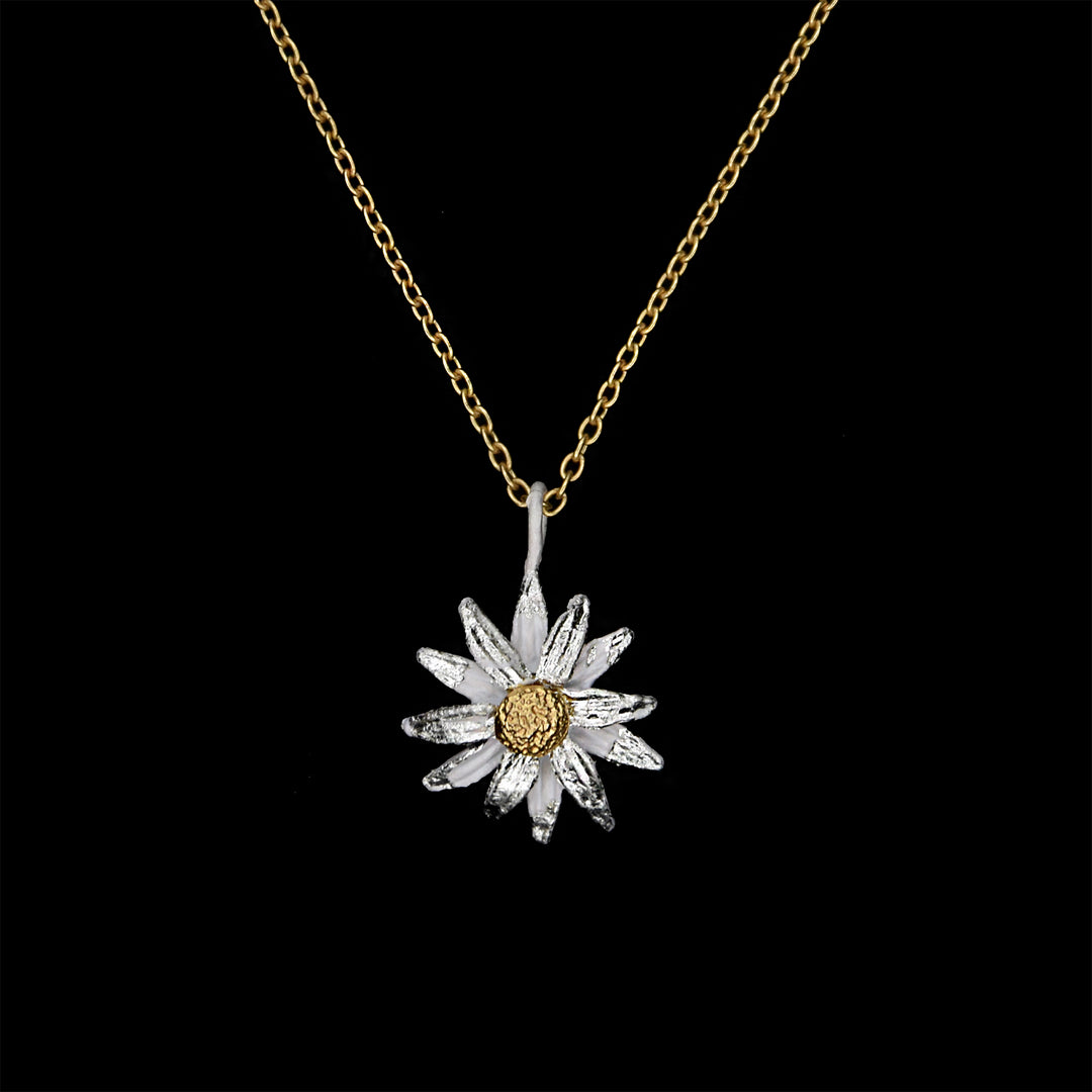 A daisy pendant with a bronze finish and white gold leaf detailing, suspended from a gold chain.