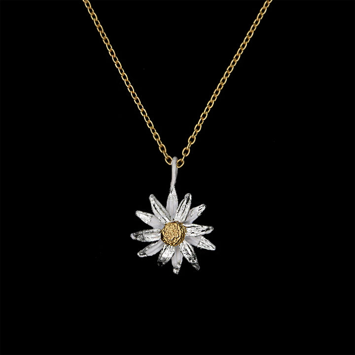 A daisy pendant with a bronze finish and white gold leaf detailing, suspended from a gold chain.