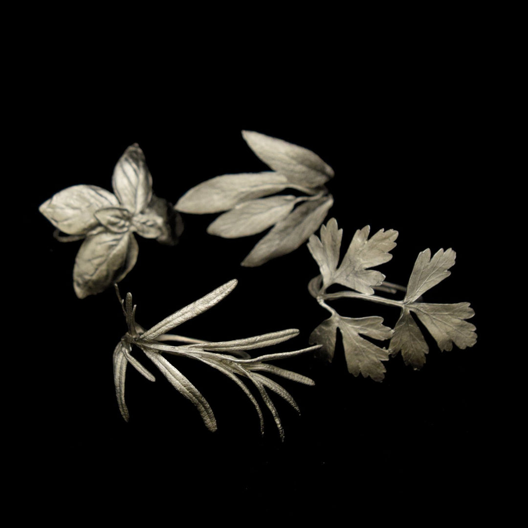 Image of the Michael Michaud Italian Herbs Assortment for Four Napkin Rings - Pewter on a black background
