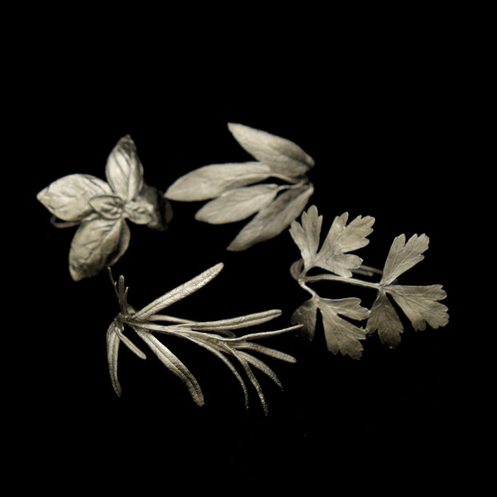 Image of the Michael Michaud Italian Herbs Assortment for Four Napkin Rings - Pewter on a black background