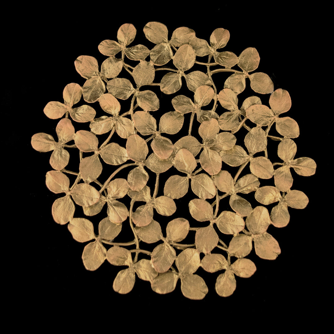 Image of the Michael Michaud Clover Trivet - Bronze on a black background