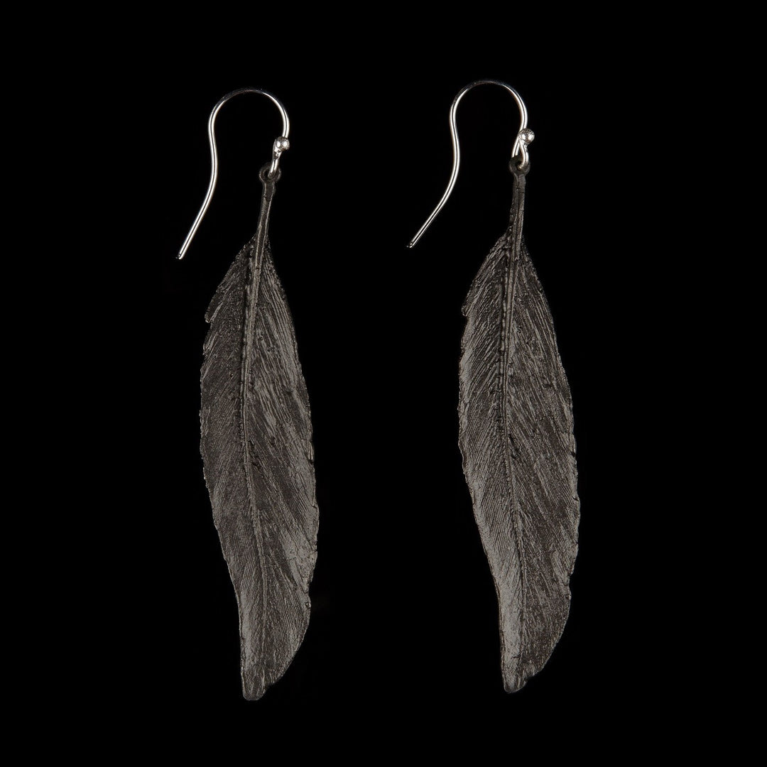 Image of the Michael Michaud Feather Earrings - Long Single Wire Gunmetal on a black background